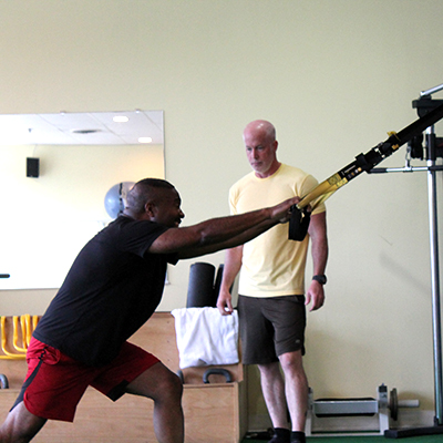 Image of Jeff Johns training a client usin the TRX Bands.